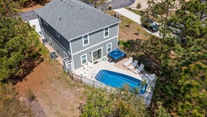 Et toetagers hus med swimmingpool, udendørs siddepladser og jacuzzi.