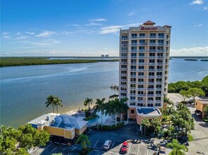A tall hotel with a 'Resort' sign, surrounded by water and palm trees.