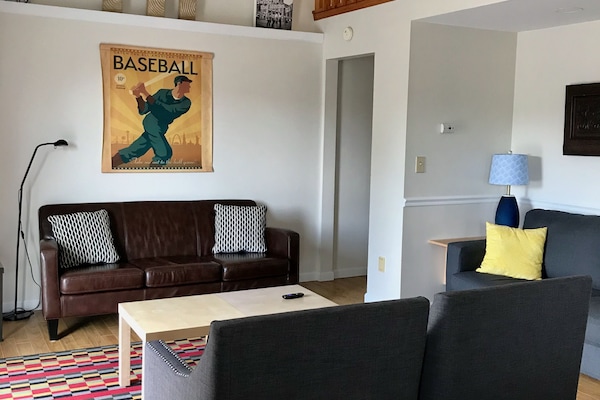 Comfy living room with cathedral ceiling and sliding door to deck.