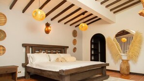 Une chambre avec un lit en bois, des décorations murales en fibres tressées et un plafond rustique.