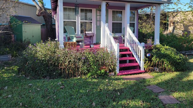 A house with a porch, a staircase, and a garden.