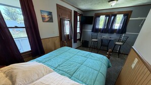 Una habitación con una cama, un escritorio y una silla.