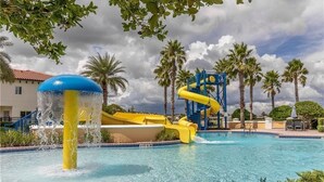 Una piscina con tobogán y zona de parque acuático.