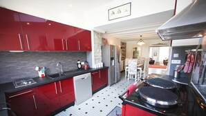 A modern kitchen with red cabinets, a dishwasher, and a stove.