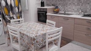 Une cuisine équipée d’une table à manger, de chaises, d’un four à micro-ondes, d’une cuisinière et de placards.