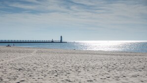 A beach with a lighthouse and pier in the background. - New Remodel! Updated Cottage near Beach and Park (Manistee)