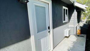 Una casa con puerta y buzón blancos, y una ventana pequeña.