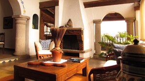 Um interior acolhedor com lareira, móveis de madeira e vista para o exterior.