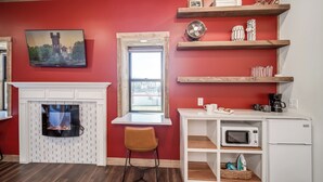 Una cocina compacta con chimenea, un comedor con ventana y un microondas.