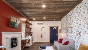 Una habitación acogedora con chimenea, un sofá y una cama.