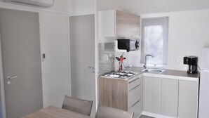 Een kleine keuken met een gasfornuis, spoelbak en moderne apparaten.