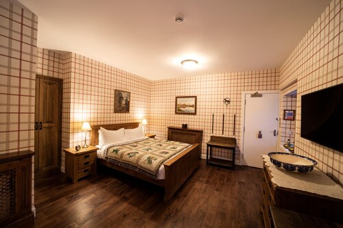 The wooden floors, vintage furniture, and tartan accents create a comfy room