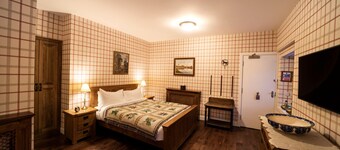 The wooden floors, vintage furniture, and tartan accents create a comfy room