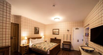 The wooden floors, vintage furniture, and tartan accents create a comfy room