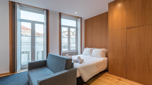 Una habitación de hotel con una cama, una silla y paneles de madera.