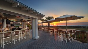 A deck with outdoor seating and a bar area overlooking the ocean at sunset. - Marriott's Surf Watch - Luxury 2 BR, 2 Bath Villa w/ full kitchen that sleeps 8! (Hilton Head Island)