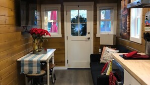 A cozy kitchen with wooden walls, a dining area with a table and chairs, and a small staircase leading to another level. - ALL INCLUSIVE AMENITIES:Kayak,SUP,Pedal Boat,PingPong,Pickleball,Movie Nt &MORE! (Nice)