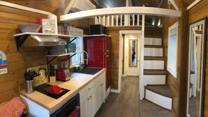 A compact kitchen with wooden walls, a red refrigerator, and a white staircase. - ALL INCLUSIVE AMENITIES:Kayak,SUP,Pedal Boat,PingPong,Pickleball,Movie Nt &MORE! (Nice)