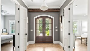 A hallway with a double door, wooden flooring, and a ceiling fan. - Better on Brenda | Private Pool + Spa | Private Beach Access | 4 Bikes (Seacrest)