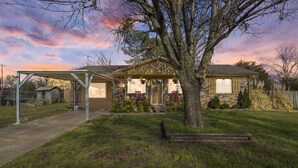 A house with a covered porch, a garage, and a well-maintained lawn.