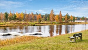 Un parque junto al lago con un muelle de madera y un banco.