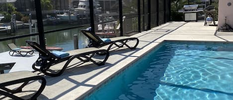 Relax by the pool with a view of the marina and surrounding buildings.