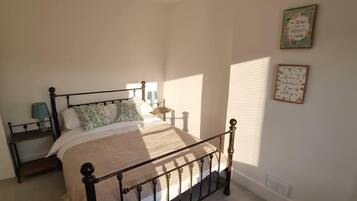A bedroom with a bed, bedside tables, and wall decorations.