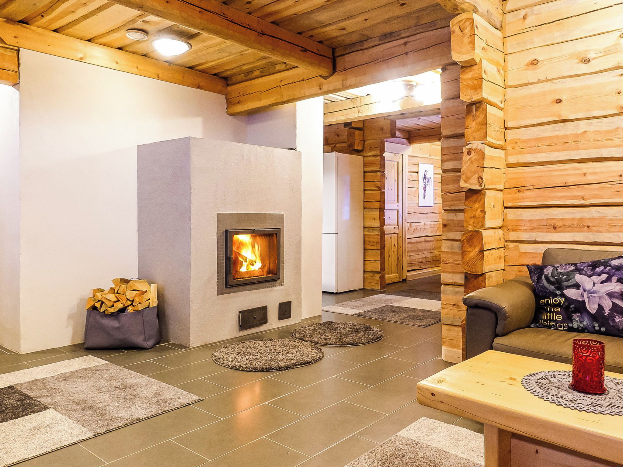 A cozy room with a fireplace, a sofa, and a table with a decorative item.
