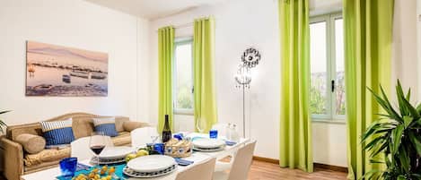 Un comedor con una mesa lista para comer, un sofá y un cuadro en la pared.