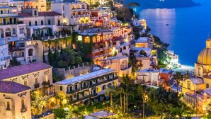 A coastal town with terraced buildings, a prominent church with a dome, and a view of the sea. - Nice apartment for 4 guests with WIFI, A/C and TV (Sorrento)