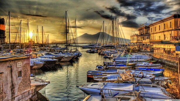 A marina with boats docked along the waterfront, buildings adjacent to the water, and a mountainous backdrop. - Nice apartment for 4 guests with WIFI, A/C and TV (Sorrento)
