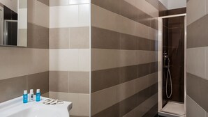 A bathroom with a white sink, three toiletries, and a shower area with a glass door. - Nice apartment for 4 guests with WIFI, A/C and TV (Sorrento)