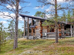 A log cabin with a wooden deck, large windows, and a covered porch. - Nilimella by Interhome (Inari)