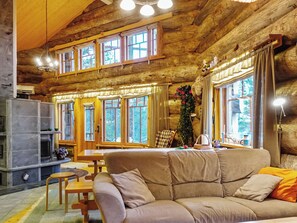L’intérieur d’un chalet confortable, avec un canapé, une table à manger et une cheminée.