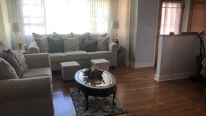 Un salon comprenant un canapé, des fauteuils, une table basse et un tapis.