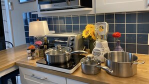 A kitchen with a microwave, toaster, stove, and various pots and pans. - Luxury Retreat in Prime Downtown Spring Green Location  (Spring Green)
