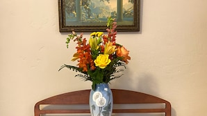 A wooden desk with two drawers and a vase of flowers on top. - Luxury Retreat in Prime Downtown Spring Green Location  (Spring Green)