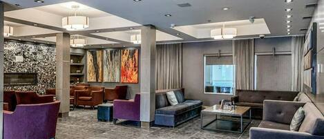 A spacious lobby with modern seating, a stone accent wall, and a large abstract painting.