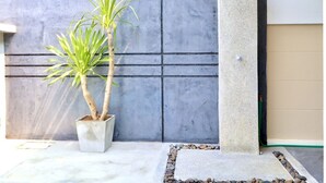 A concrete planter with two palm plants against a grey wall. - Luxury Pool Villa A10  (Bang Lamung)