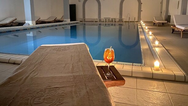 A swimming pool with lounge chairs and a sunbed.