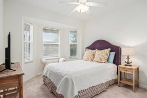 Cozy retreat with a large bed, bedside table, and TV.