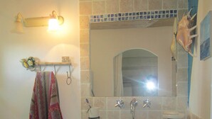 A bathroom with a sink, mirror, and towel rack.