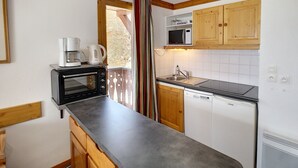 Cocina compacta equipada con microondas, cafetera y lavavajillas.
