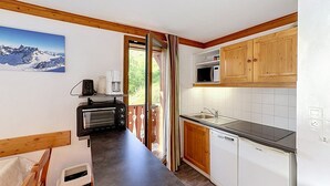 Cocina compacta con microondas, tostadora y lavabo.