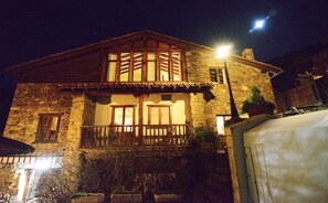 Un bâtiment en pierre doté d’un balcon, d’une fenêtre visible et d’un lampadaire.