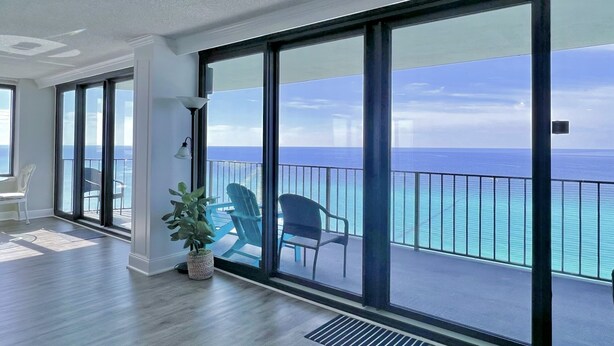 A spacious balcony with large windows overlooking the ocean. - Picturesque Beachfront Condo- Spacious  Balcony, 2BD/2BA, Pool & Tiki Bar (panama city beach)