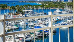 A marina with numerous boats docked, surrounded by greenery and a cityscape in the background. - CORNER Unit with 11th Floor Waikiki Ocean, Lagoon & Marina Views! Washlet! (Honolulu)