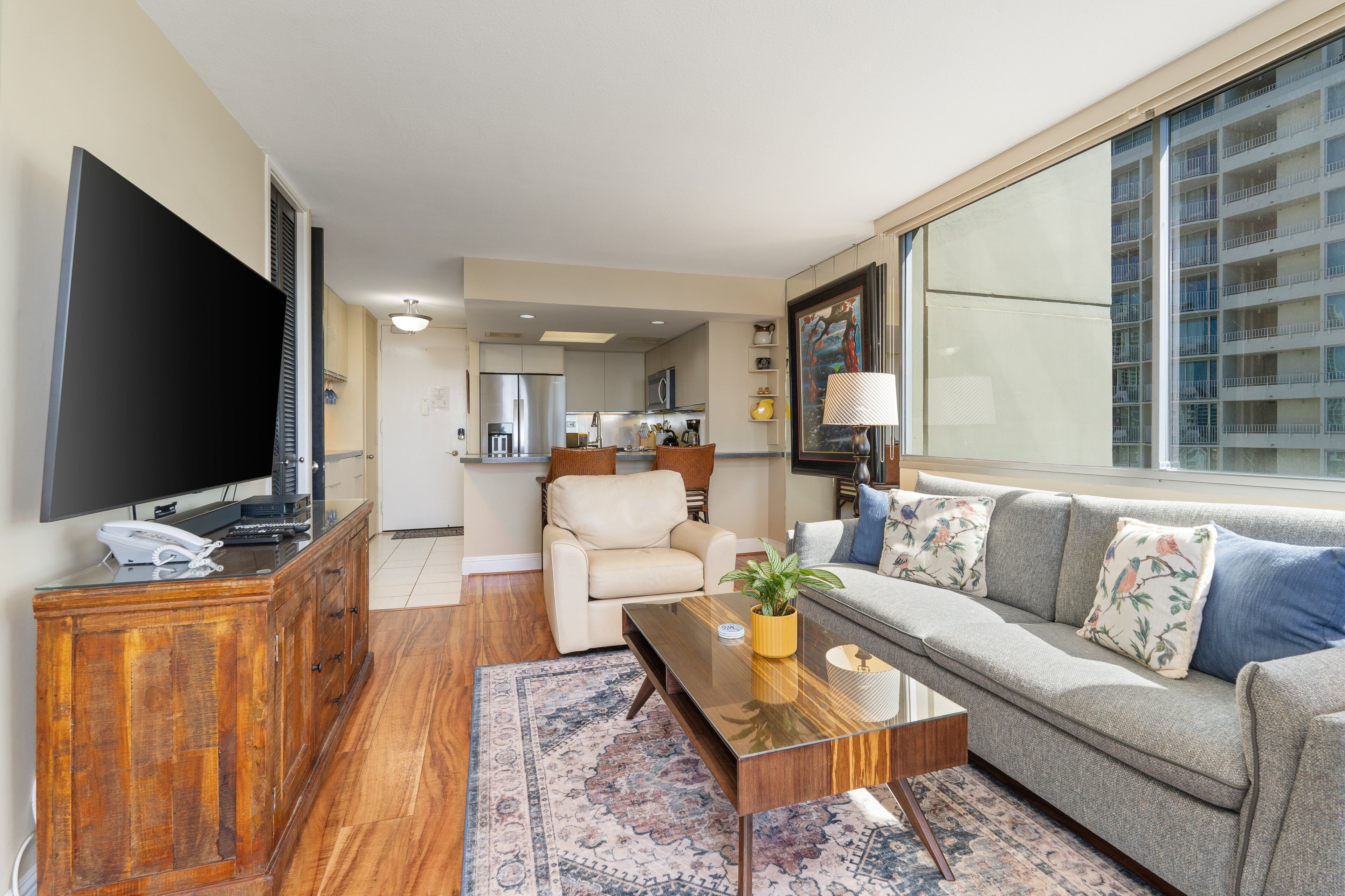 Una sala de estar moderna con un sofá, una mesa de centro, un televisor y un mueble de madera.