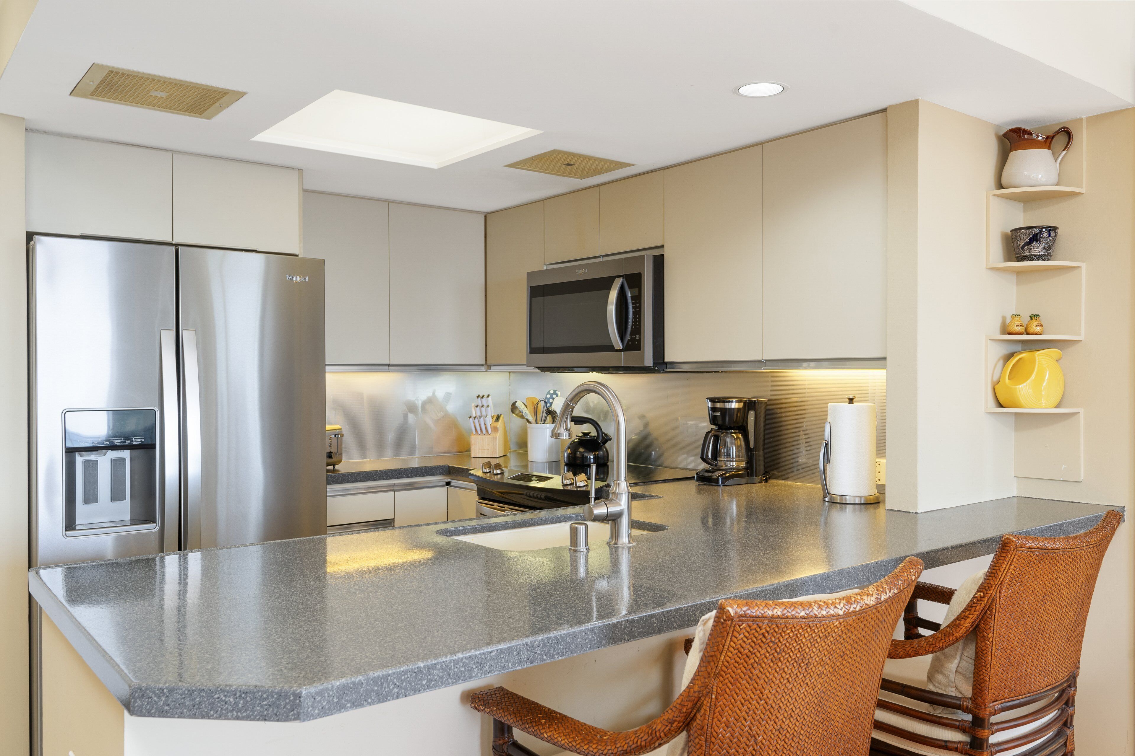 A modern kitchen with a stainless steel refrigerator, a microwave, and a coffee maker.