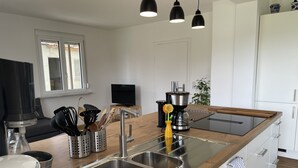 A modern kitchen with stainless steel appliances, a wooden countertop, and a built-in sink.